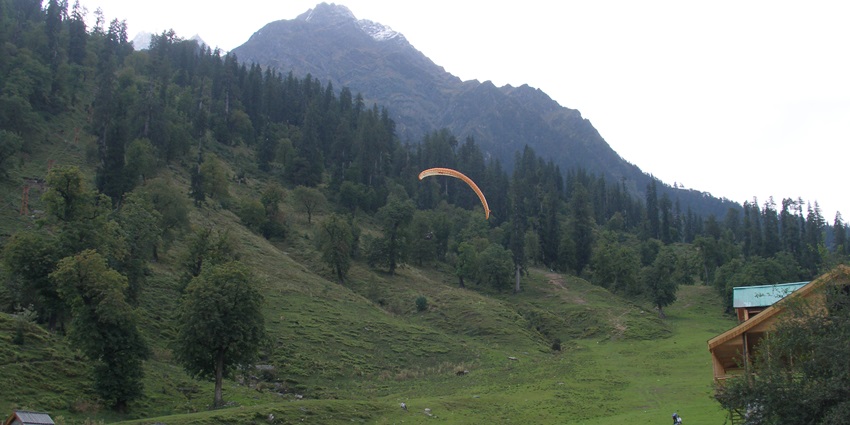 A picture of a scenic valley in Himachal with people paragliding in the clear weather
