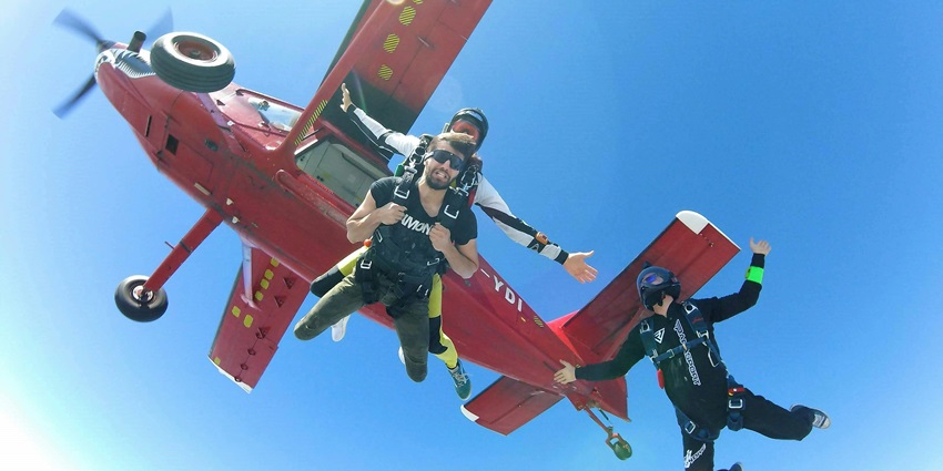 Skydivers forming a formation in the sky over Peterborough, demonstrating coordinated jumps.