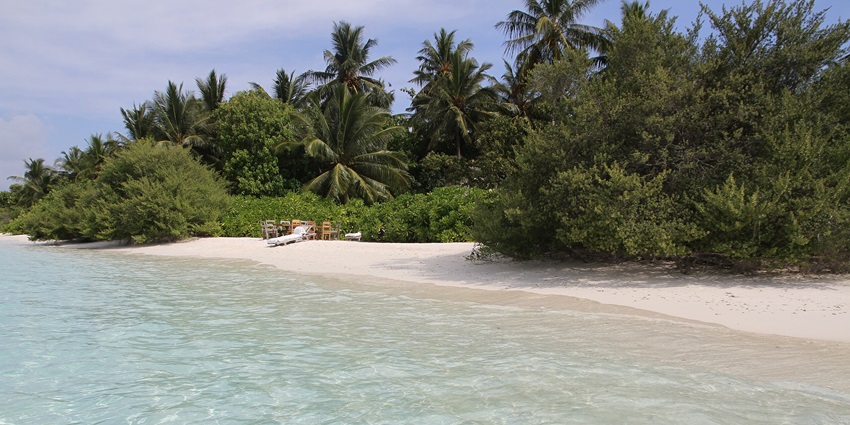 A picture of a mesmerising white sand beach with turquoise sea water around the shore