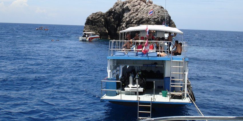 A boat approaching an island for scuba diving