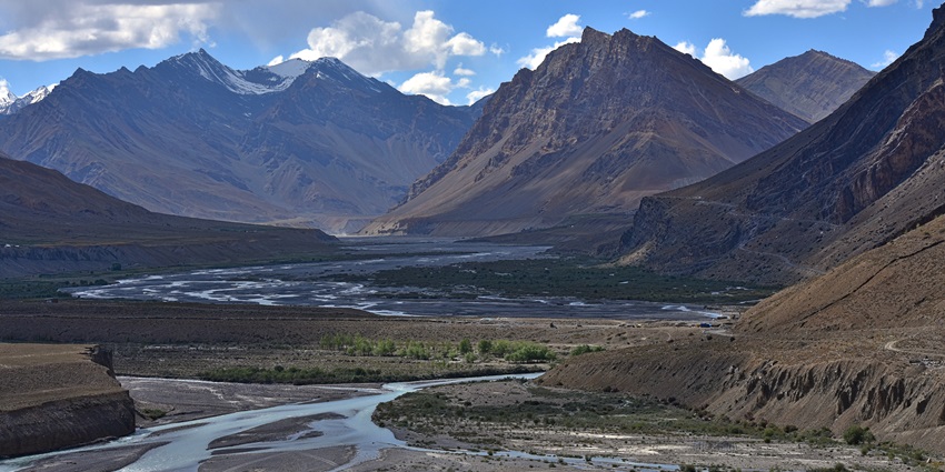 Scenic view of Spiti River near Kaza with rugged mountains and clear blue sky.