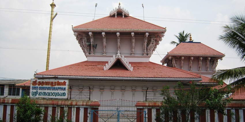 frontal view of a traditional Hindu temple in Palakkad, surrounded by pine trees