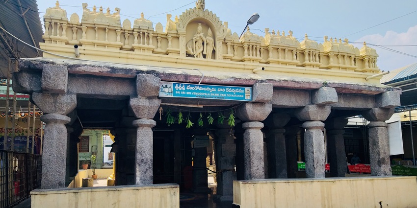 A picture of the entrance of a temple with traditionally built walls having intricate carvings