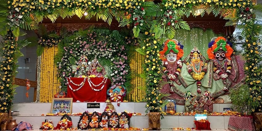 A picture of a prayer house with idols of gods and goddesses dressed up in luxury clothes and garlands