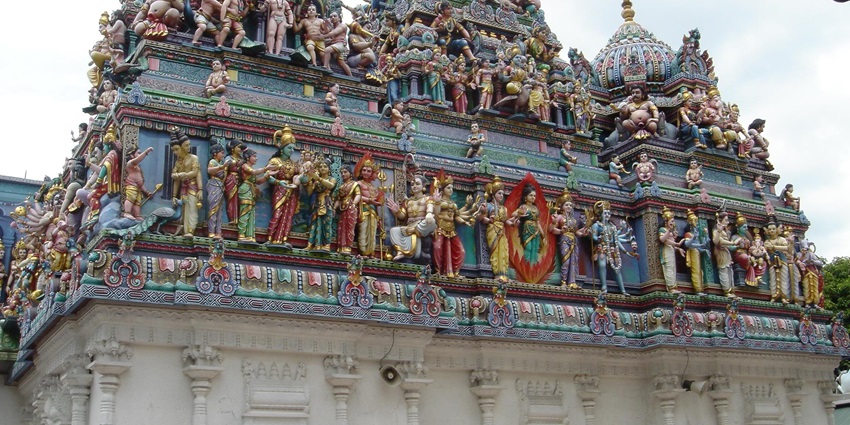 A picture of a Hindu temple with idols of numerous deities on its wall