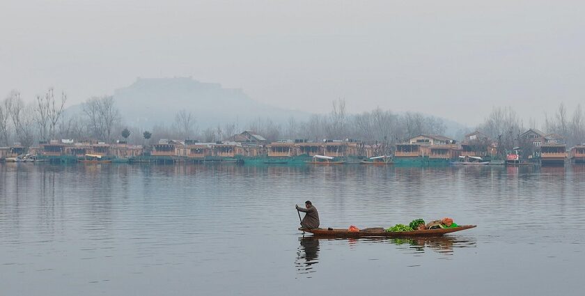 View of man selling vegetables and fruits on a Shikara in Dal Lake with a scenic backdrop