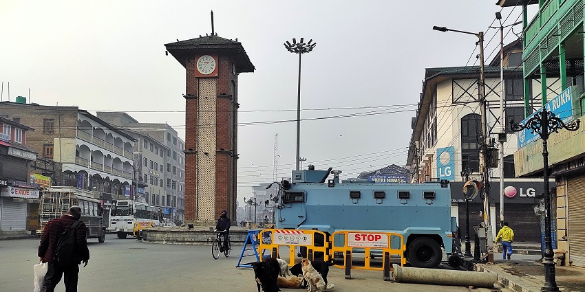 An image of the famous Old Clock Tower at Lal Chowk with multiple shops in the background.