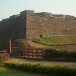 A picture of the St. Angelo Fort taken from a distance with the nearby gardens visible along with the walkway