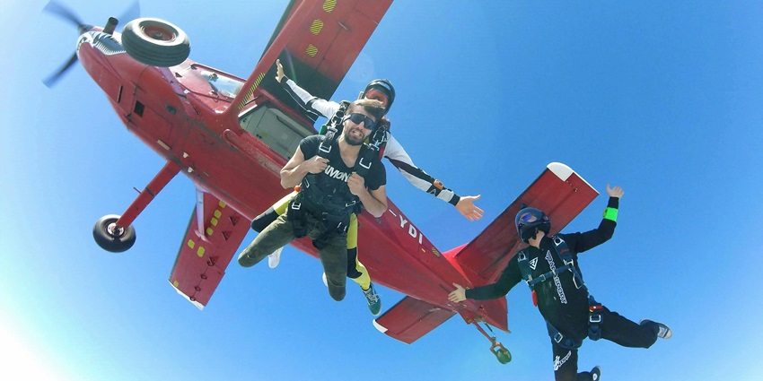 Snapshot of a diver taking a jump from the plane with a Tandem pilot on the back