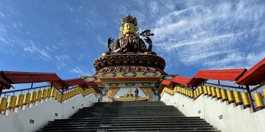 A beautiful picture of a three-handed Buddha with a clear blue sky in the background