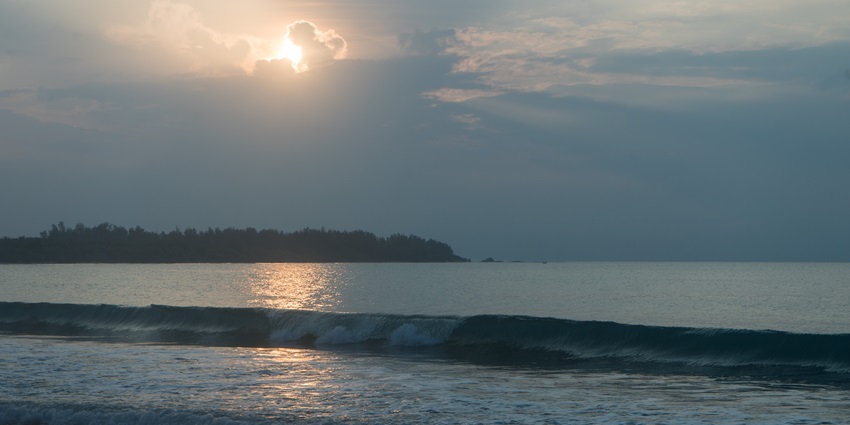 Sunrise at Kalkudah Beach with golden light reflecting on calm waters and a peace shoreline.