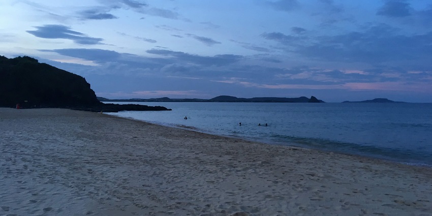 A scenic view of Bai Xep beach with calm blue waters and a sandy shoreline.