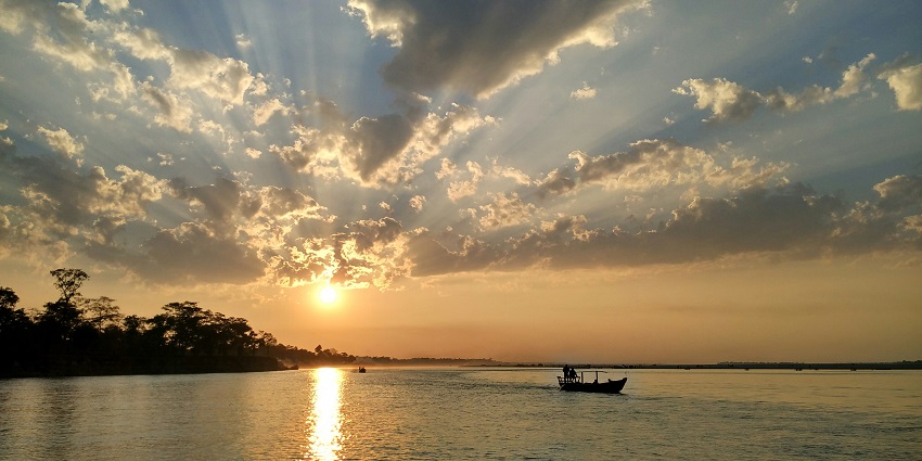 Sunset at the Brahmaputra River, with vibrant hues reflecting off the tranquil waters.