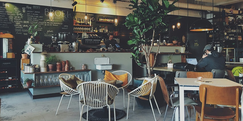 Interior of a coffee shop with cozy seating, wooden decor, and warm ambient lighting.