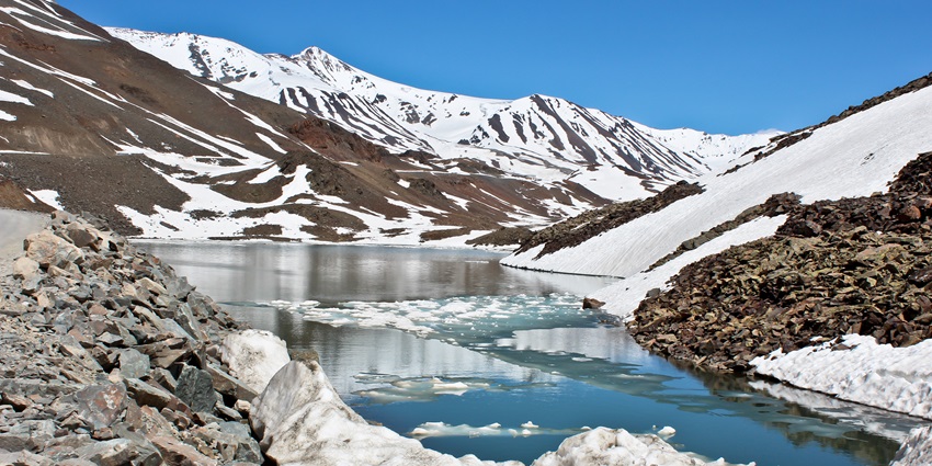 Suraj tal lake nestled amidst the snow covered Himalayan range, offering a enchanting sight