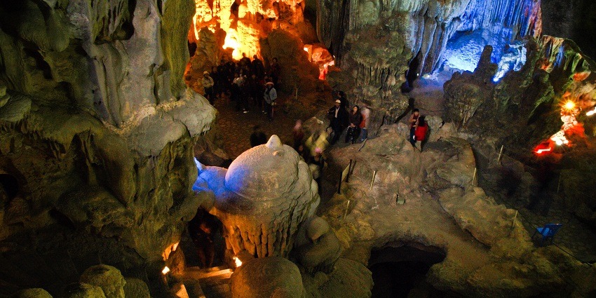 An inside view of a cave in Vietnam which is lit in multiple colours and lightning.