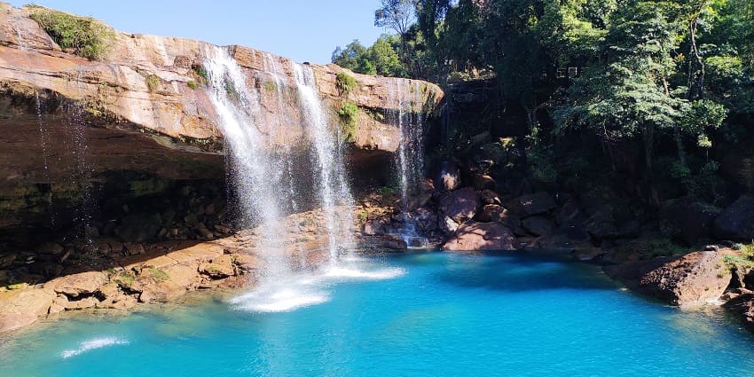 A mesmerising view of a cascading waterfall with crystal-clear turquoise waters.