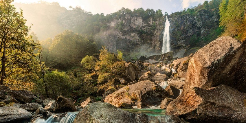 A stunning view of a waterfall surrounded by lush green meadows during the daytime.