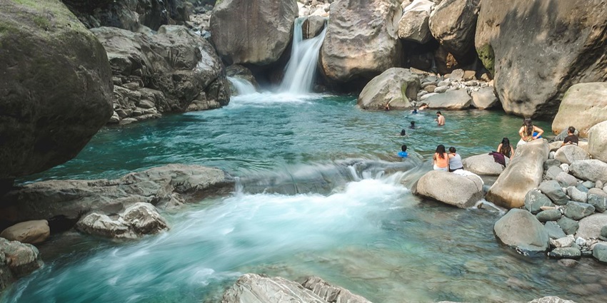 People swimming near the waterfall - one of the best things to do in Mukkam Waterfalls