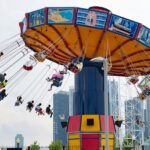 People enjoying at swing carousel with scenic views - theme parks in Malaysia