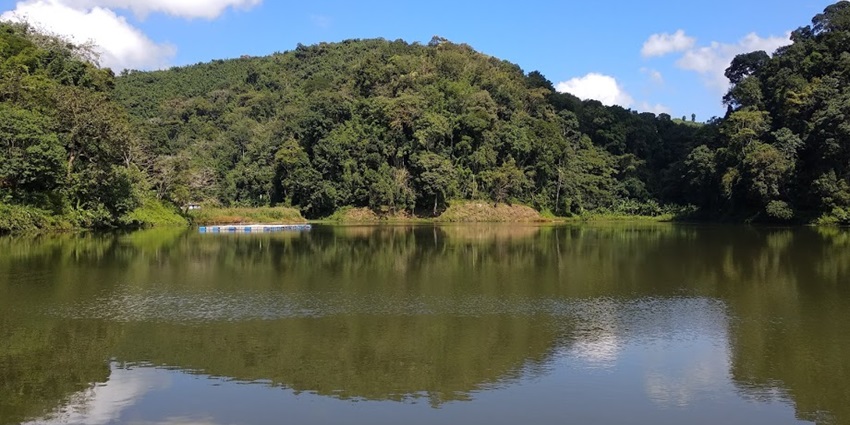 Serene view of Tam Dil Lake in Mizoram, surrounded by lush green hills