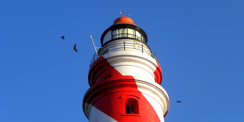 A tall lighthouse of red colour located near the St. Thomas Fort in Kerala