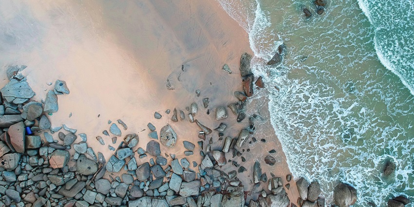 An idyllic view of Tanjung Asam Beach featuring pristine golden sands and rocky cliffs.