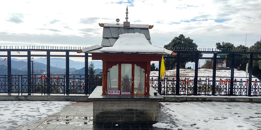 A beautiful temple covered in snow among the scenic hills in Shimla