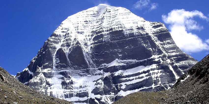 A captivating view of a rocky mountain peak covered in snow and clouds in the background.