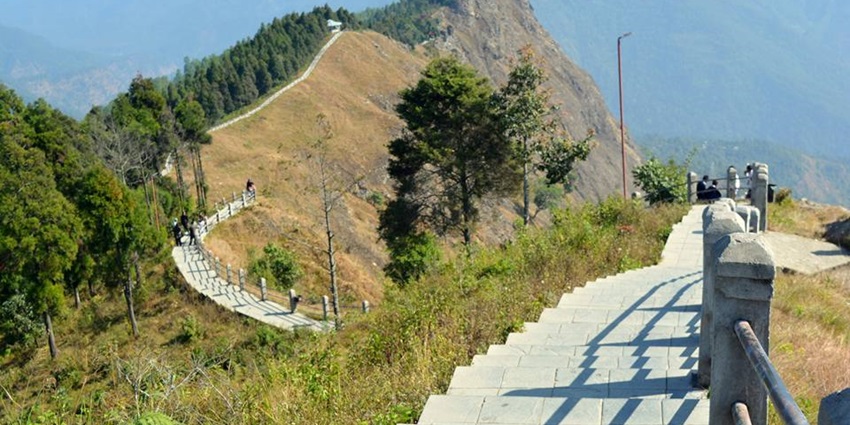 A picture showing a cliff along with a stairway to trek across the cliff