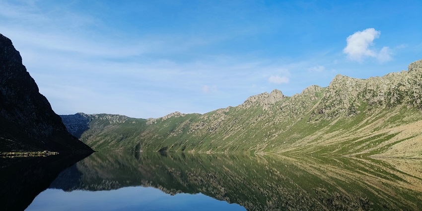A breathtaking view of the Tarsar Lake in Anantnag surrounded by green-capped mountains.