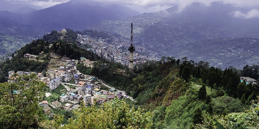 A scenic view of lush mountains and town settlement of Sikkim, as seen from Tashi View Point
