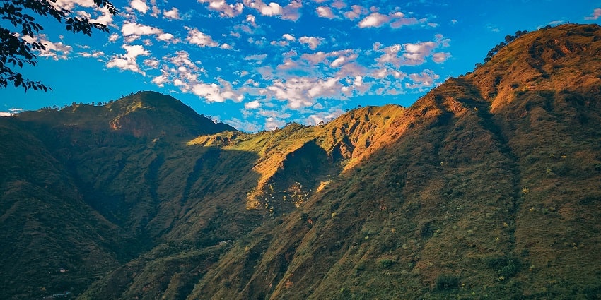 A mesmerising view of a valley in Himachal Pradesh under dense clouds during the day.
