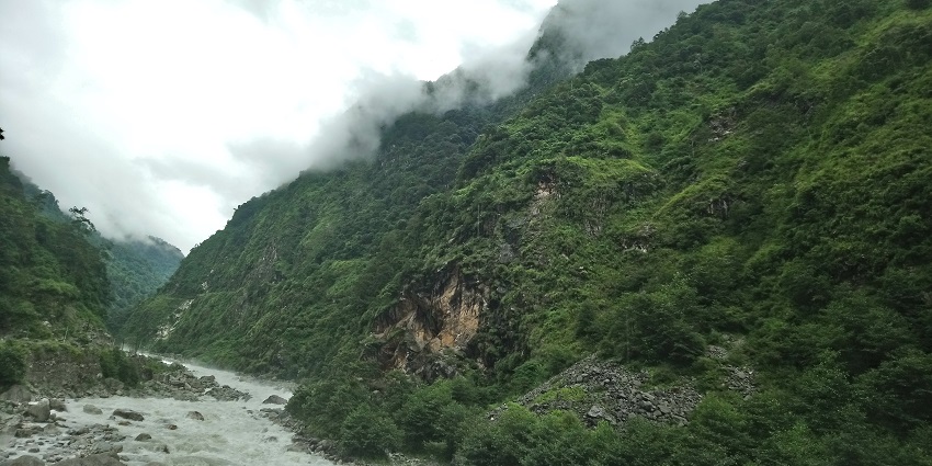 A breathtaking view of the Teesta River in Sikkim surrounded by greenery during the day.
