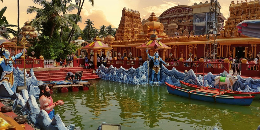 The Scenic image of an ancient temple with a pond full of the statues of Devas and Gods