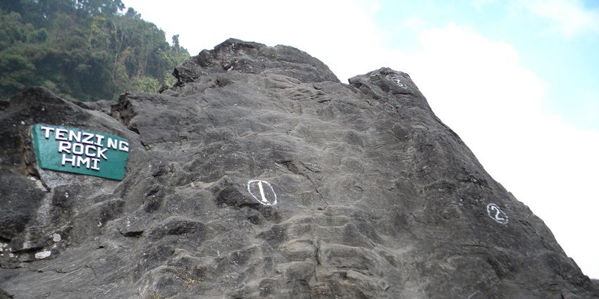 Natural rock formation at Tenzing Rock, Darjeeling, with carving and climbers
