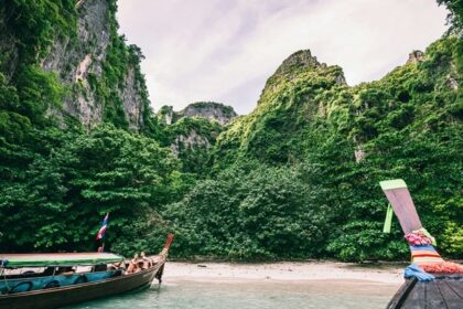 Boats decked on the seashore of the region surrounded by lush greenery and azure waters.