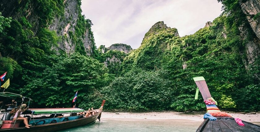 Boats decked on the seashore of the region surrounded by lush greenery and azure waters.