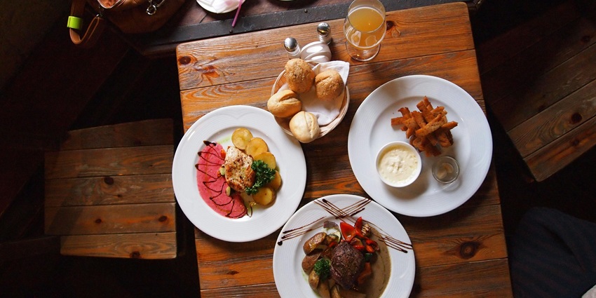 A picture showing a table in a restaurant with various food items placed