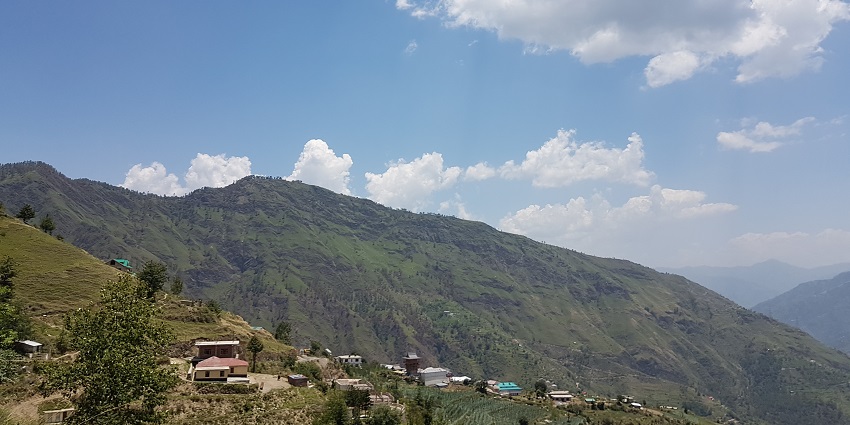 Scenic view of Theog, Shimla, showcasing lush green hills and serene landscapes.