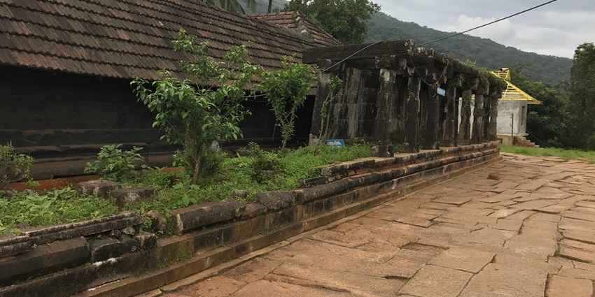 A scenic view of the ancient Thirunelli Mahavishnu Temple with lush greenery all around
