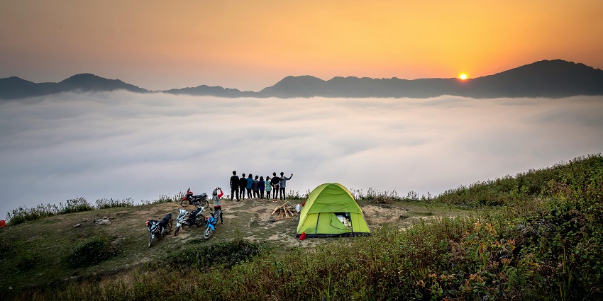 Mindblowing view of a dome camp with a group of people and bikes in front during the day.