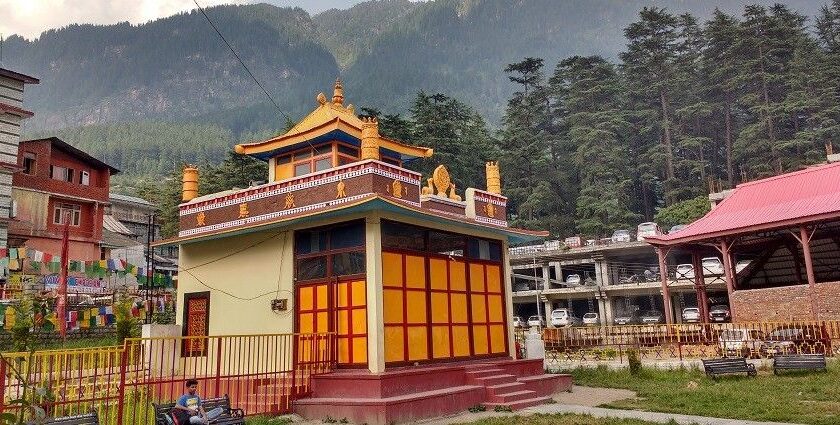 A picture of a Tibetan monastery in Manali with the beautiful green mountains in background