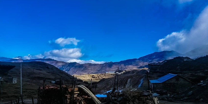 Tinjure Trek Alt Text: A scenic landscape with mountain peaks in the background