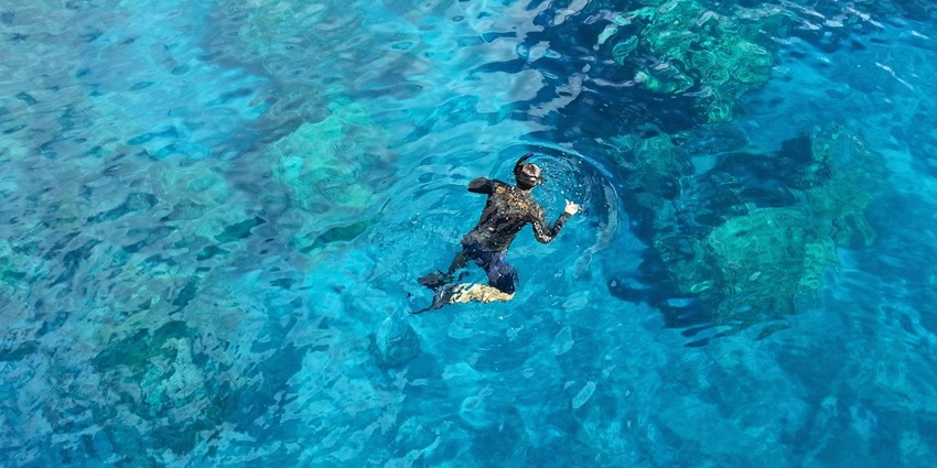 A picture of a person enjoying snorkelling in the beautiful blue waters of Phuket