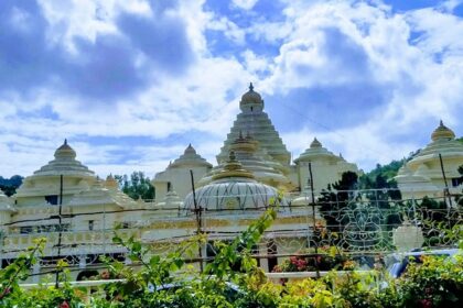 A fascinating view of a white historical monument surrounded by greenery during the day.