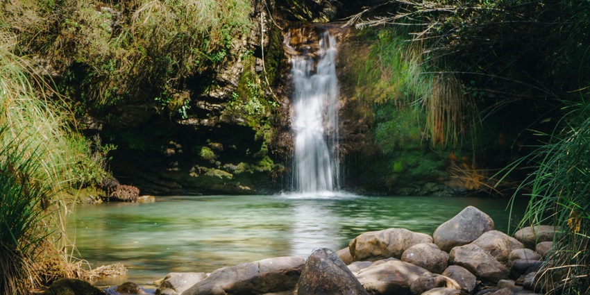 View of Tizu Valley Fall with water cascading down rugged cliffs into a lush valley.