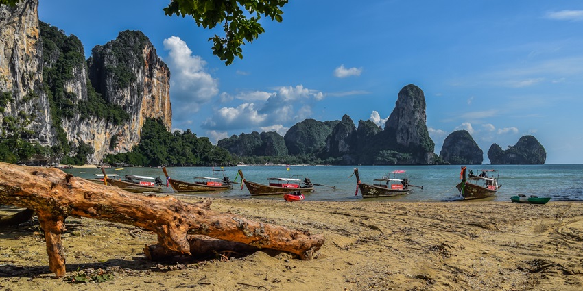 Tranquil Tonsai Beach in Krabi with lush cliffs, crystal-clear waters, and sandy shore.