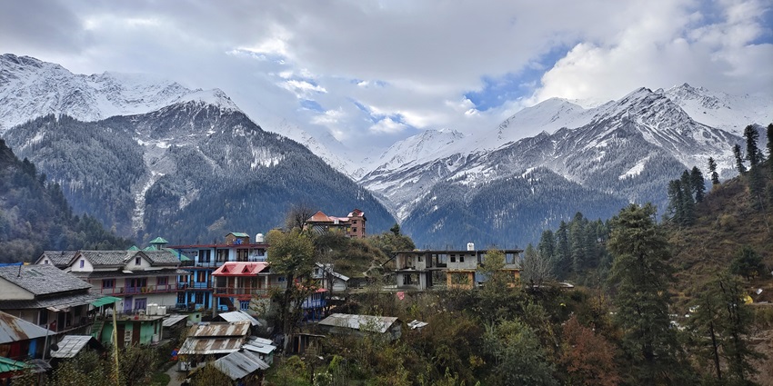 Scenic view of Tosh village with lush greenery and a backdrop of snow-clad mountain peaks