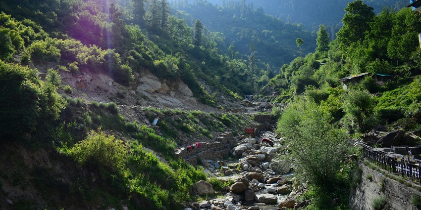 Image of a serene autumn stream flows through colourful foliage - Offbeat places near Manali.